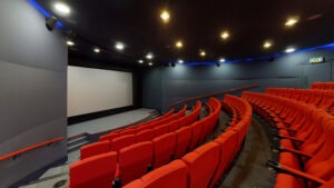 Empty cinema with screen and rows of red seats
